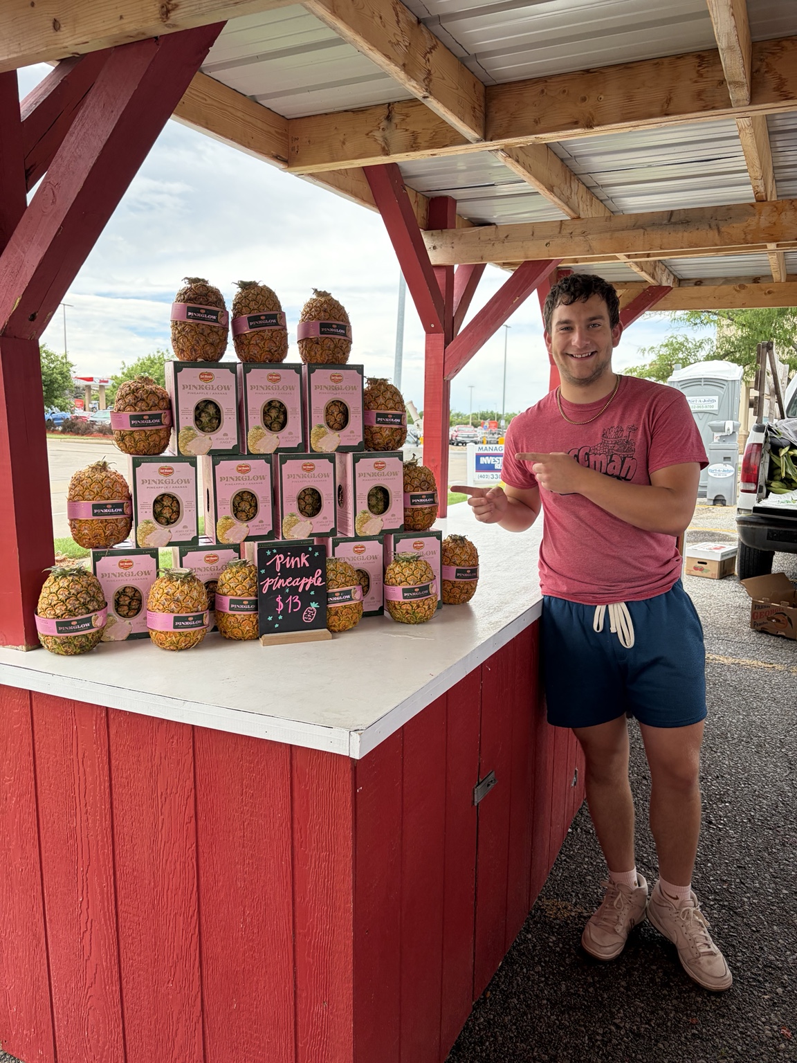 Huffman Produce team member with a pink pineapple display